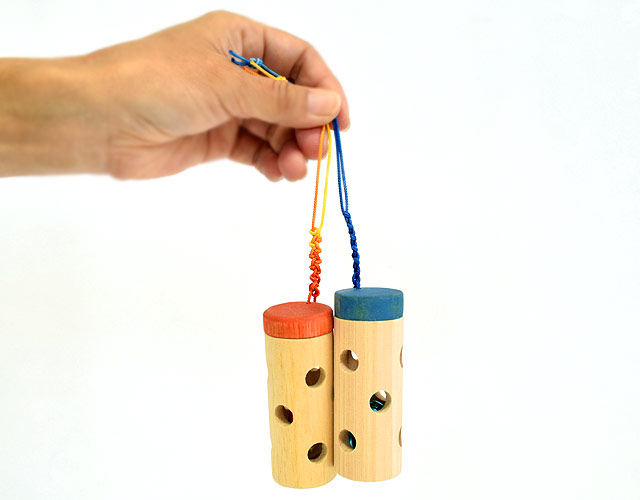穴の中にビー玉と鈴が入ったひのきのベビーラトル